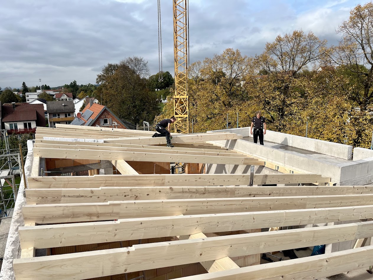 Dachstuhl – 3-Familienhaus  Aufrichten des Dachstuhls eines Neubaus auf massivem Mauerwerk. Solide Holzkonstruktion, sauber ausgeführt und fachgerecht montiert.